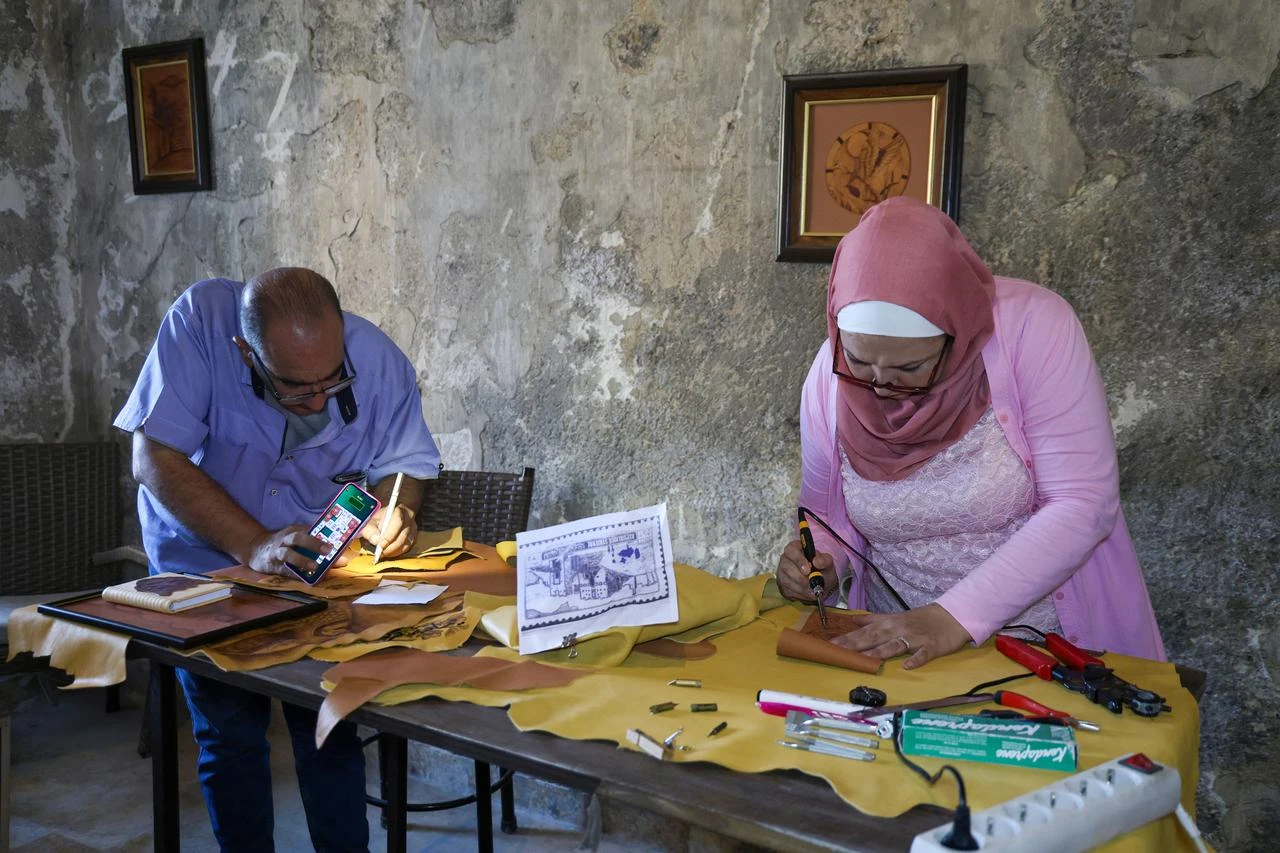 Syrian artisan Yememe Turkmeni works to preserve the traditional art of leather burning, a craft that is at risk of disappearing in Aleppo, Syria, on July 31, 2026. (AA Photo)