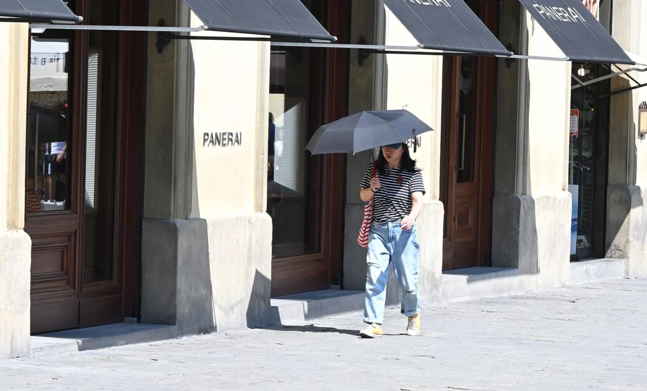 A woman uses an umbrella for shade during extreme heat in Florence, Italy, Aug. 3, 2026. (AA Photo)