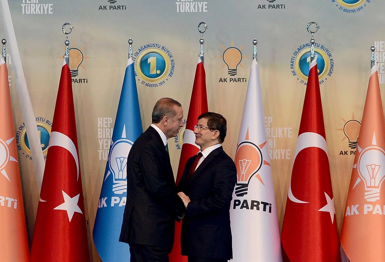 Then-Turkish Prime Minister and head of ruling Justice and Development Party (AK Party) Recep Tayyip Erdogan (L) and then-Turkish Foreign Minister and AK Party's new chairman candidate Ahmet Davutoglu (R) shake hands during the 2014 AK Party Extraordinary Congress at Ankara Arena Stadium in Ankara, Türkiye on August 27, 2014. (AA Photo)