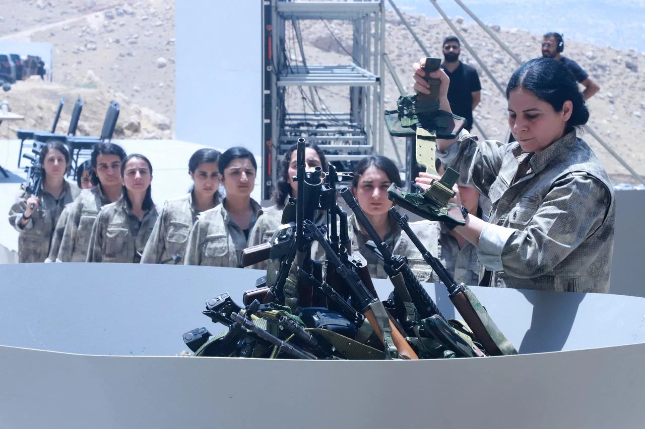 Members of the terrorist organization PKK line up to put their weapons into a pit during a ceremony in Sulaimaniyah, in Iraq, July 11, 2025. (AFP Photo)