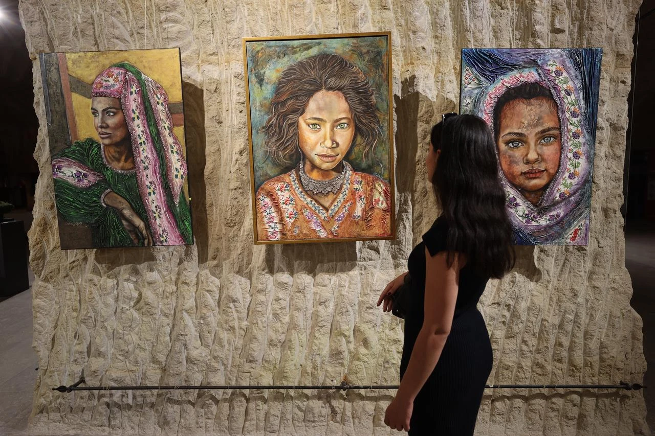 A visitor examines a series of portraits displayed during the Nevsehir Culture Route Festival in Türkiye. (AA Photo)