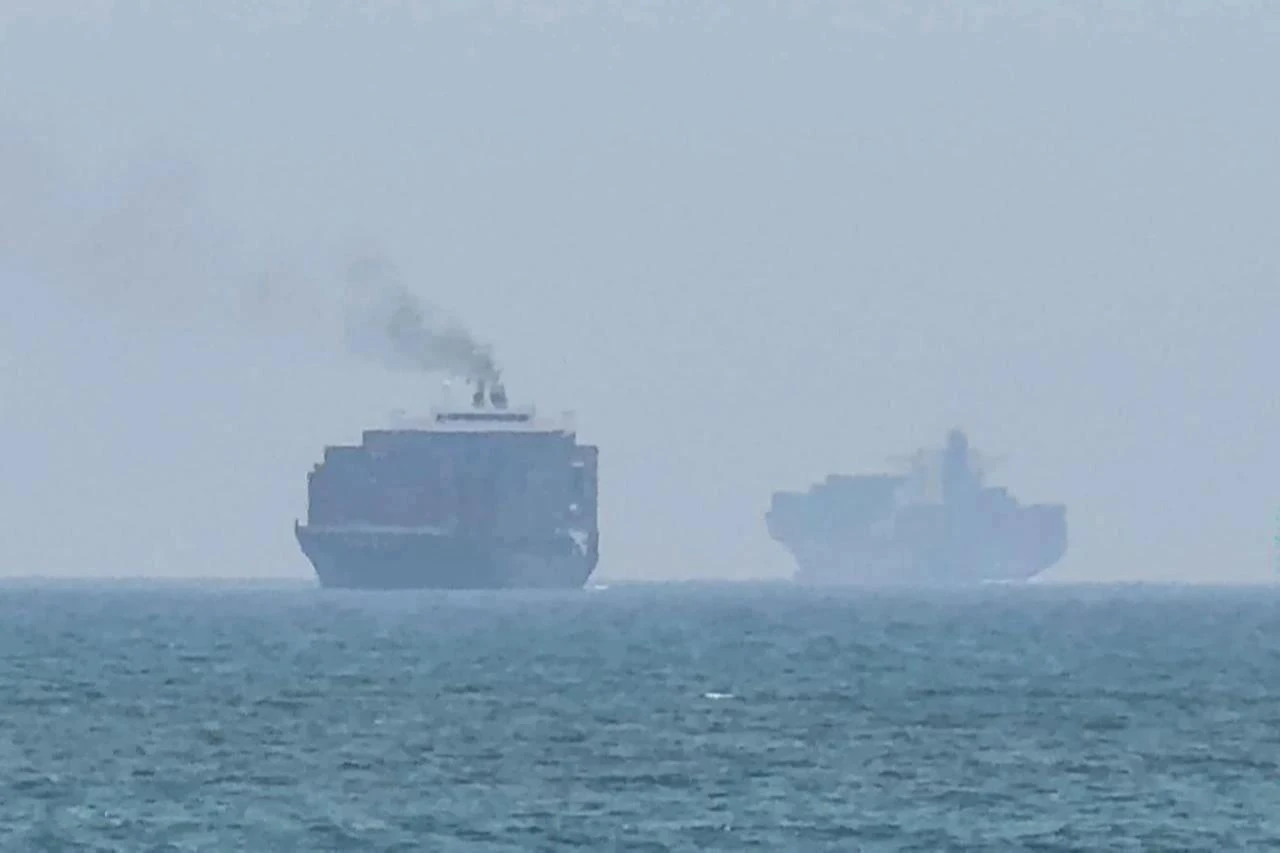 This frame grab taken from AFPTV video footage on July 12, 2026 shows cargo ships anchoring near the Strait of Hormuz off the eastern coast of the United Arab Emirates at Khor Fakkan. (AFP Photo)
