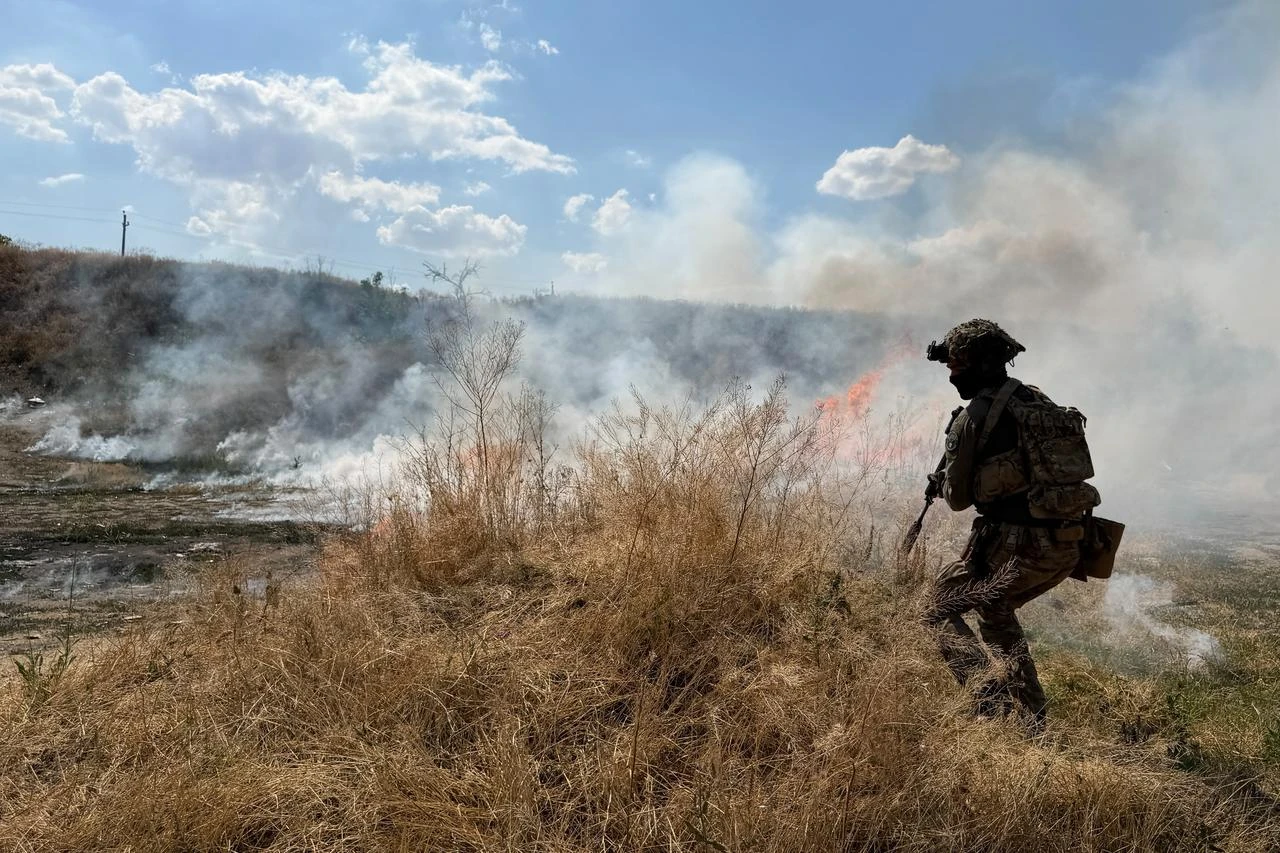 A French volunteer member from the Revanche Tactical Group takes part in a military training on a burning field at an undisclosed location, in the Zaporizhzhia region, July 3, 2026. (AFP Photo)