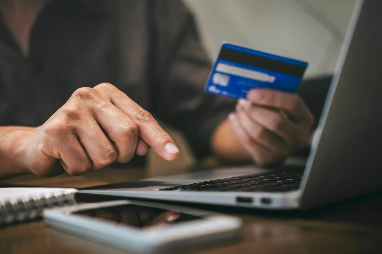 Man holding credit card and typing on laptop to do online shopping and payment. (Photo via Adobe Stock)