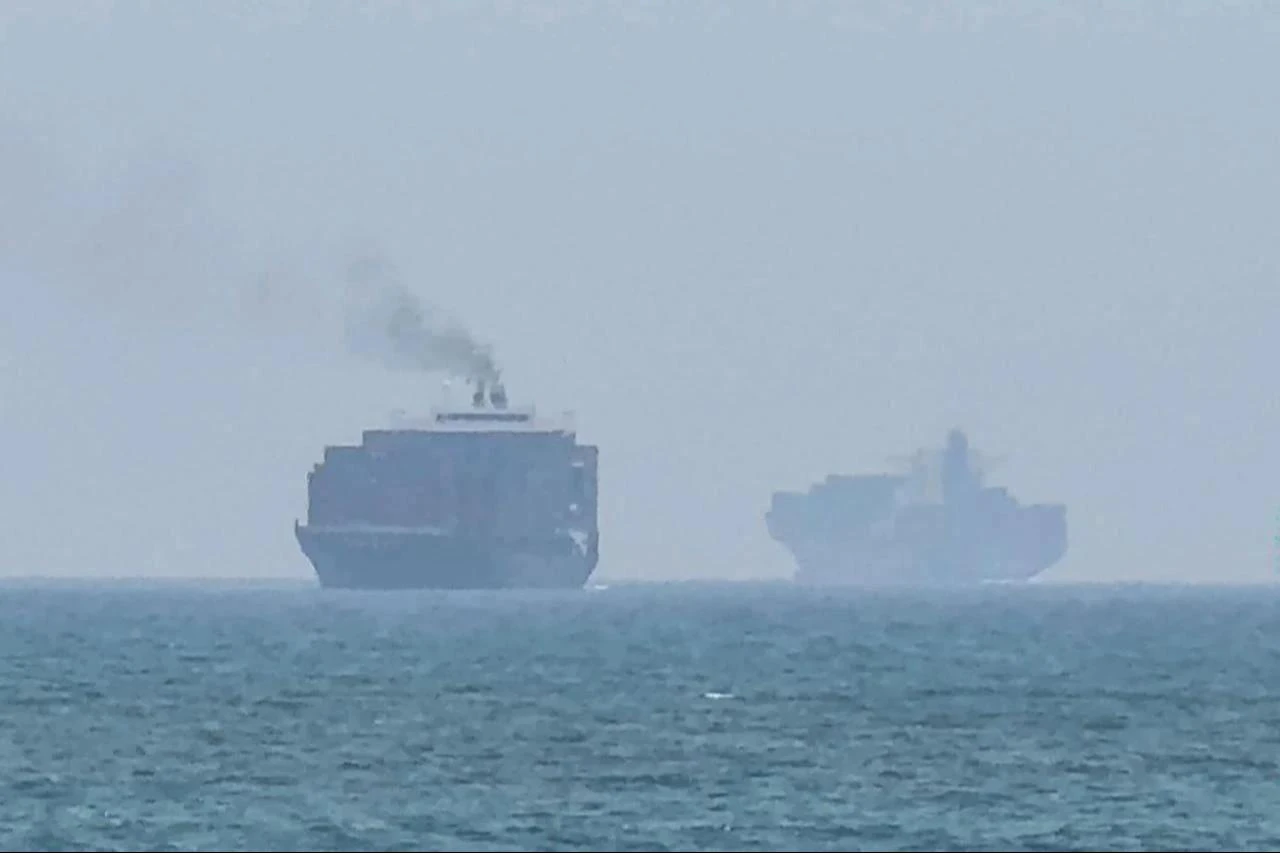 This frame grab taken from AFPTV video footage on July 12, 2026 shows cargo ships anchoring near the Strait of Hormuz off the eastern coast of the United Arab Emirates at Khor Fakkan. (AFP Photo)