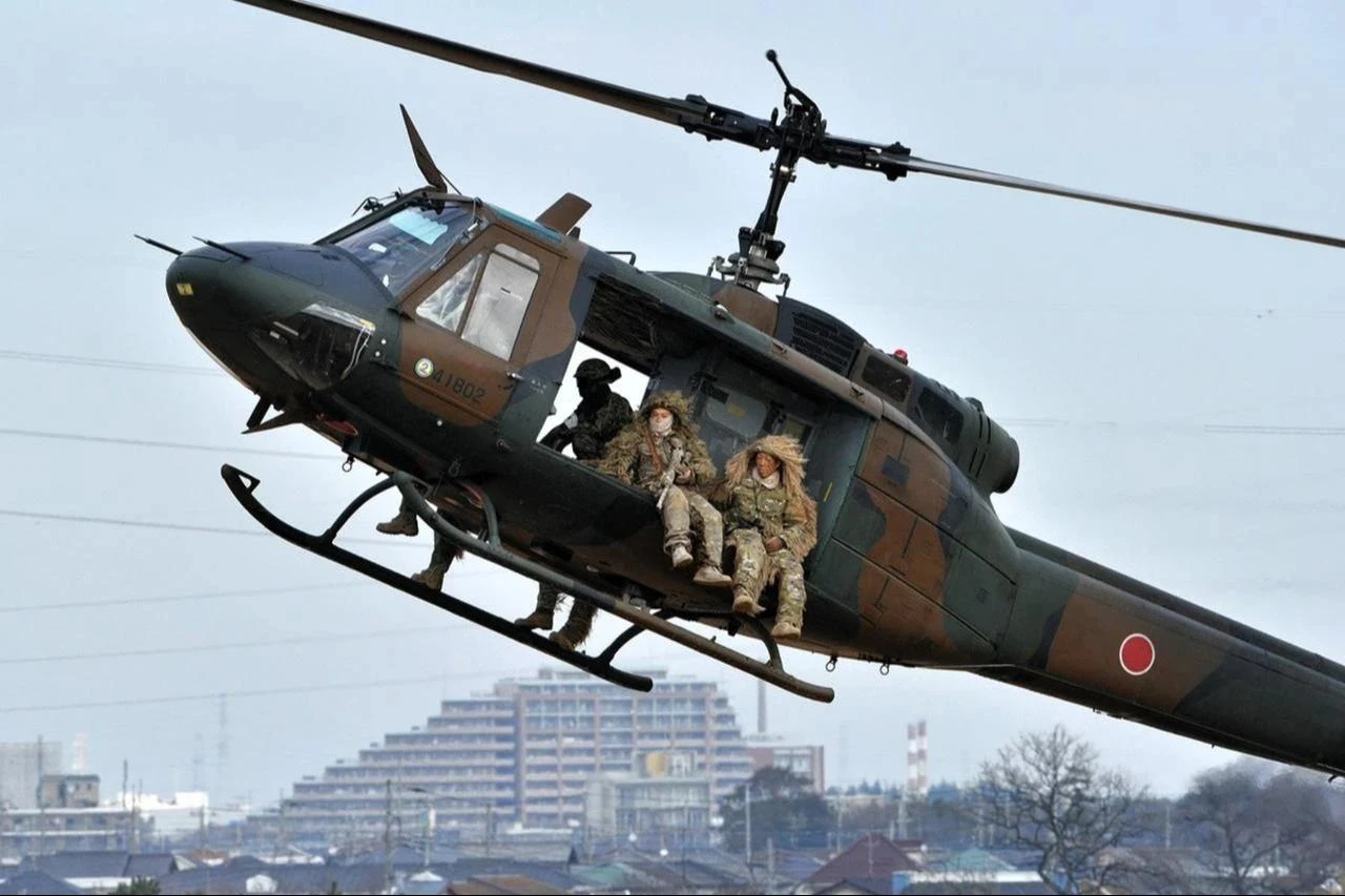 Camouflaged members of the Japanese Ground Self-Defense Forces on a UH-1 helicopter during an exercise in suburban Tokyo, accessed on Aug. 4, 2026. (AFP Photo)