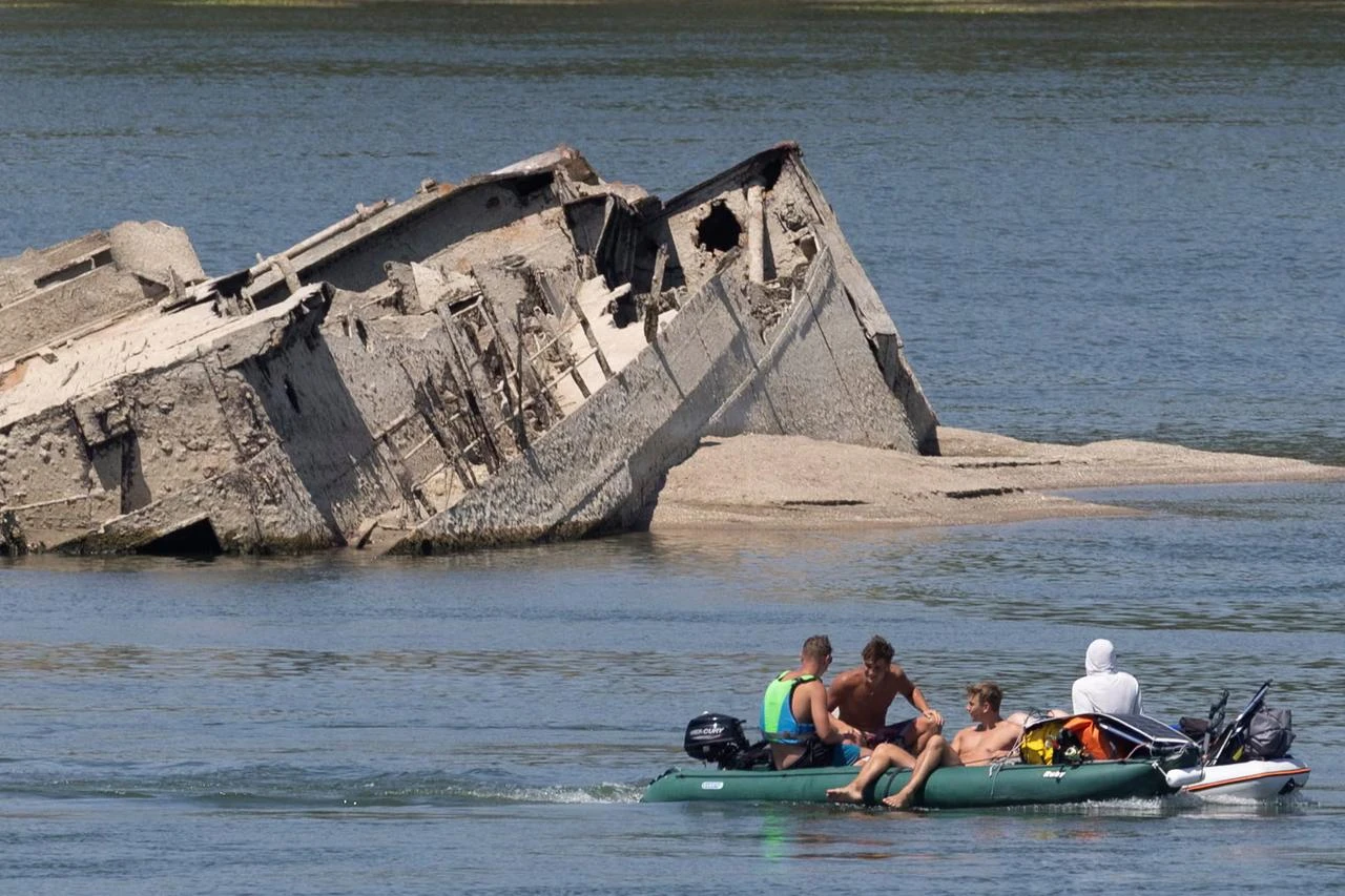 Visitors pass a Nazi German warship wreck exposed by falling water levels in the Danube River near Prahovo, Serbia. (Photo via The Chosun Daily)