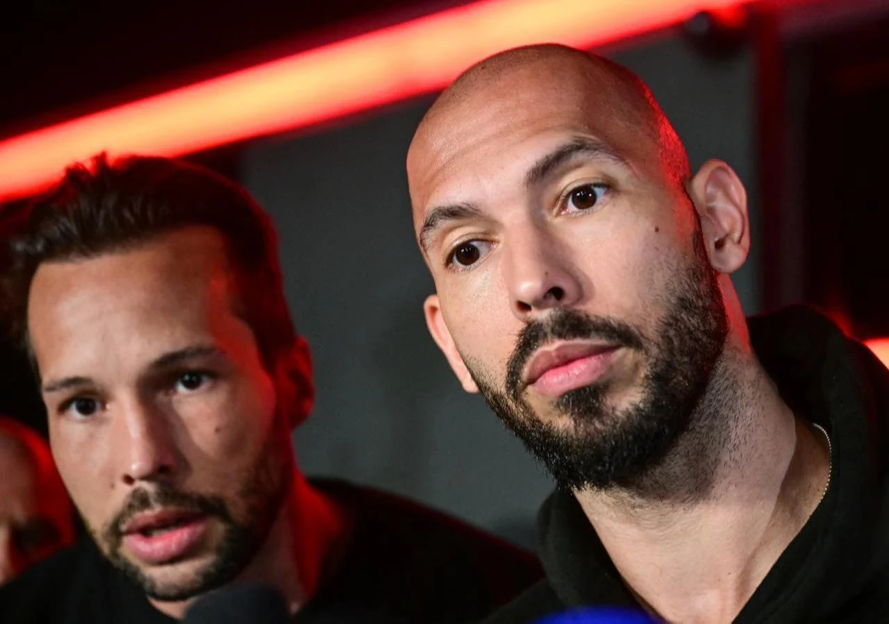 Andrew Tate (R) and his brother Tristan speak to the media as they arrive in Romania back from US, in Bucharest on March 22, 2025. (AFP Photo)