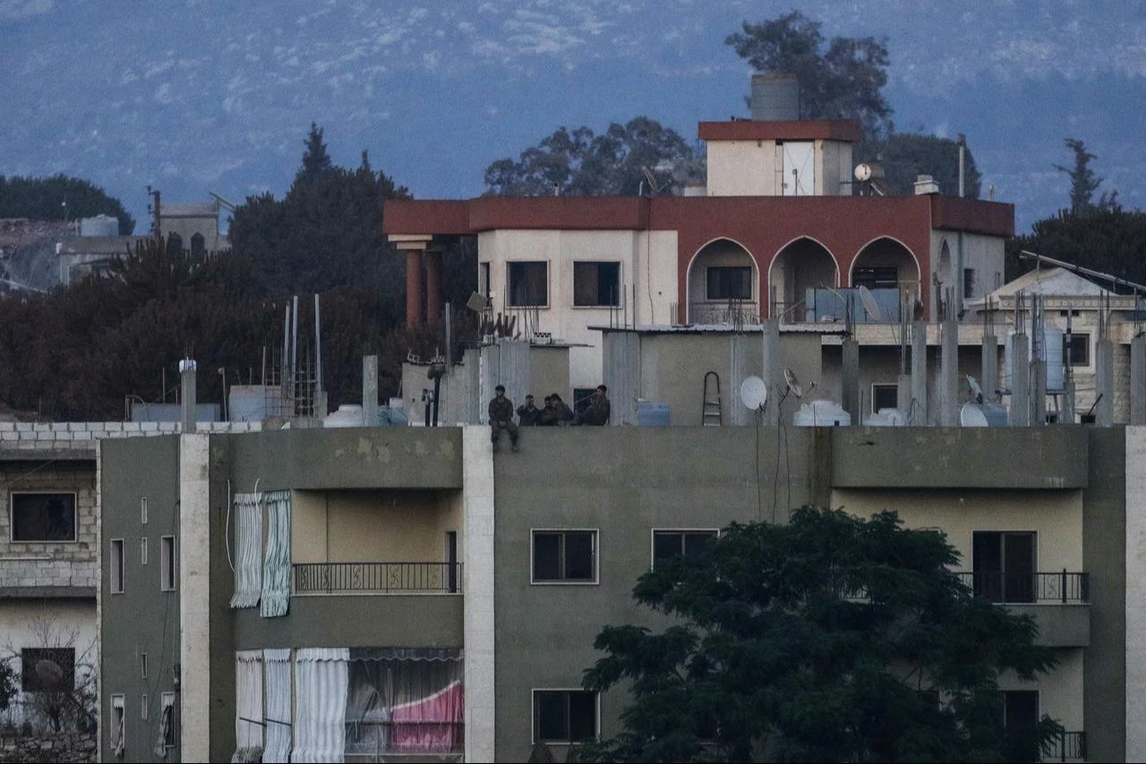 A photograph taken from the southern Lebanese village of Zawtar al-Gharbiyah, one of the first pilot zones, shows Israeli soldiers standing on the roof of a residential building in the nearby village of Zawtar al-Charkiyah, Aug. 4, 2026. (AFP Photo)