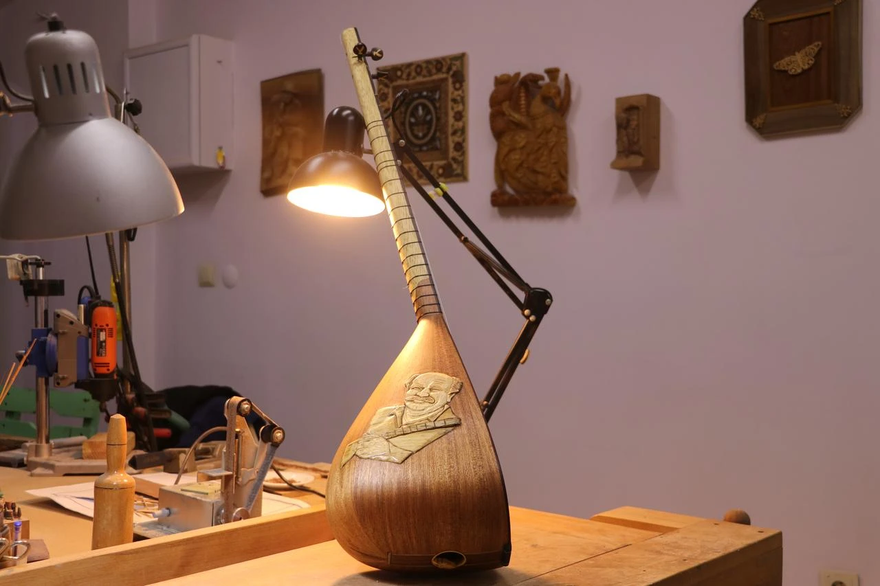 Baglama exhibited on table showing engraved artist's portrait. (AA Photo)