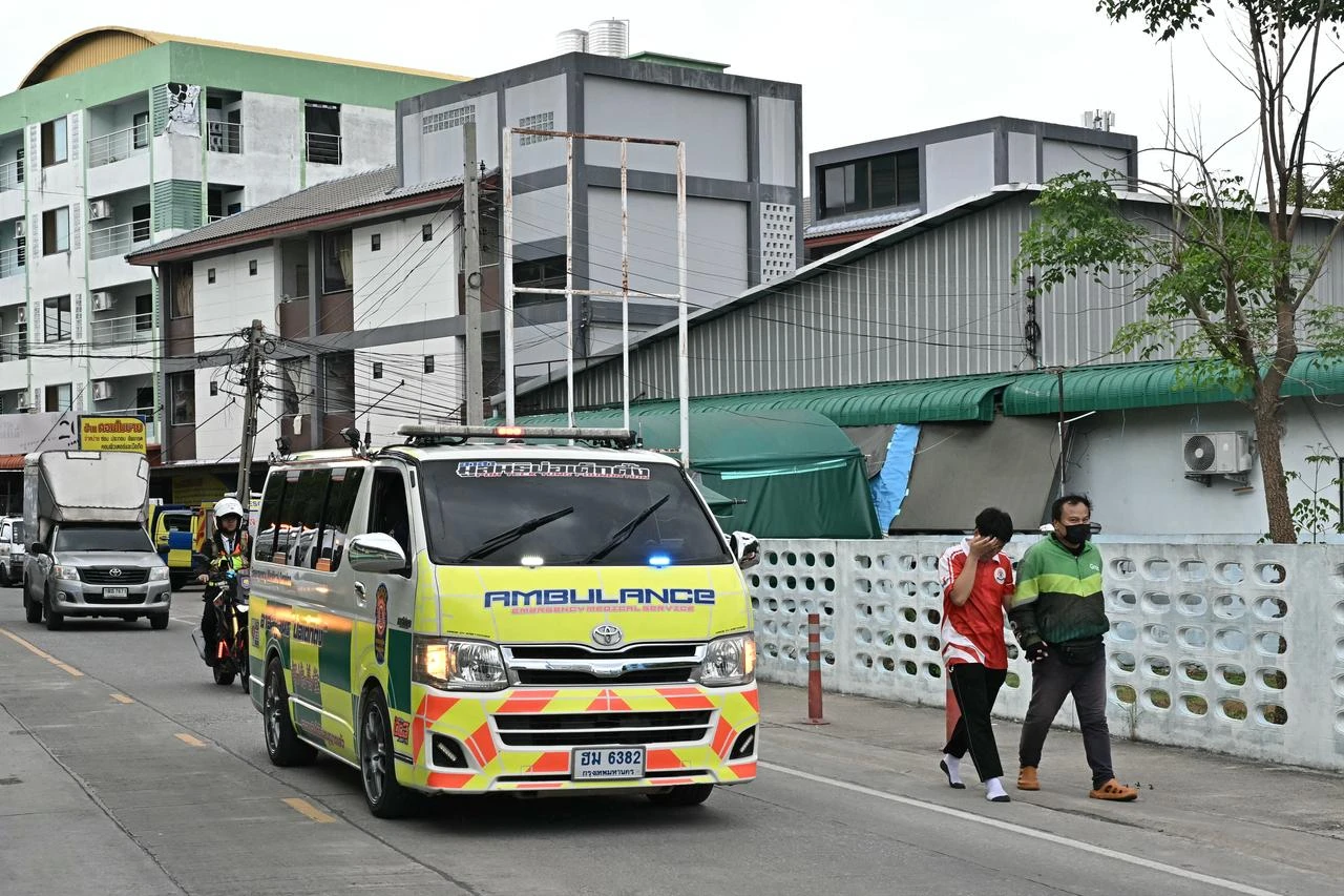 A student leaves with a parent (R) as an ambulance drives past after a school shooting in Bang Kruai district, Nonthaburi province, north of Thailand's capital Bangkok, on August 7, 2026. (AFP Photo)