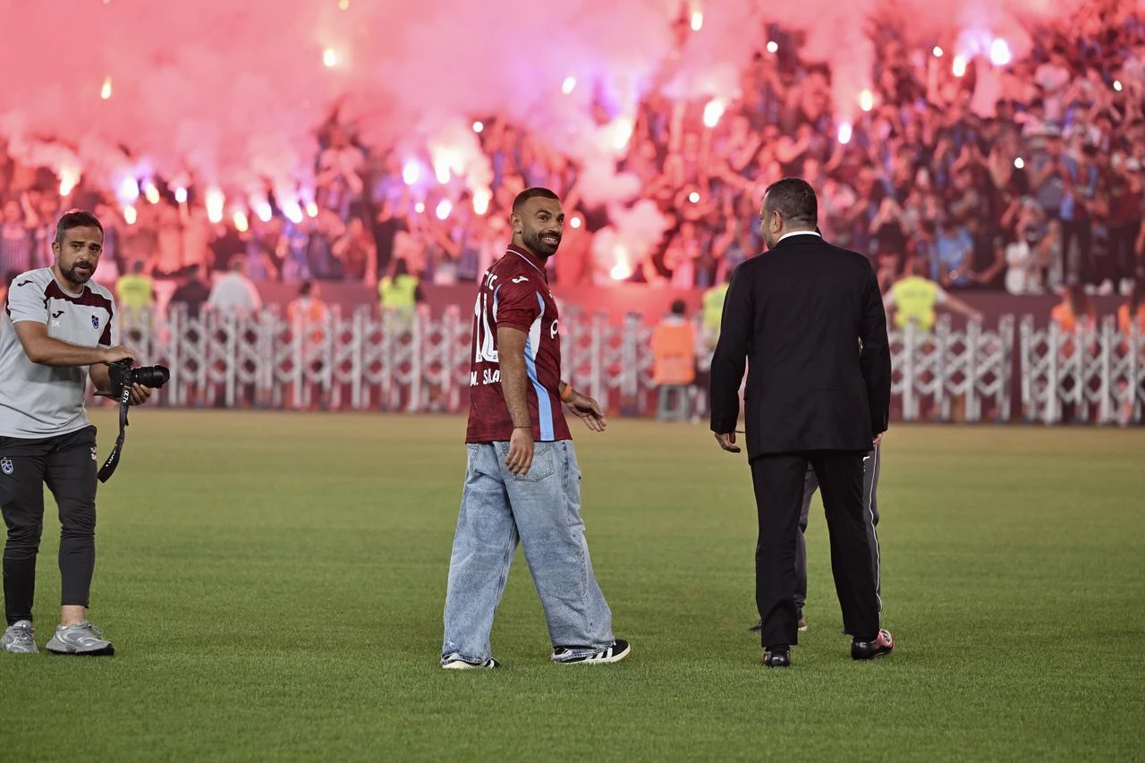 Newly signed Trabzonspor player Muhammed Salah is welcomed by fans holding flares and chanting as he walks onto the pitch with Trabzonspor President Ertugrul Dogan during a signing ceremony at Papara Park in Trabzon, Türkiye, on August 6, 2026. (AA Photo)