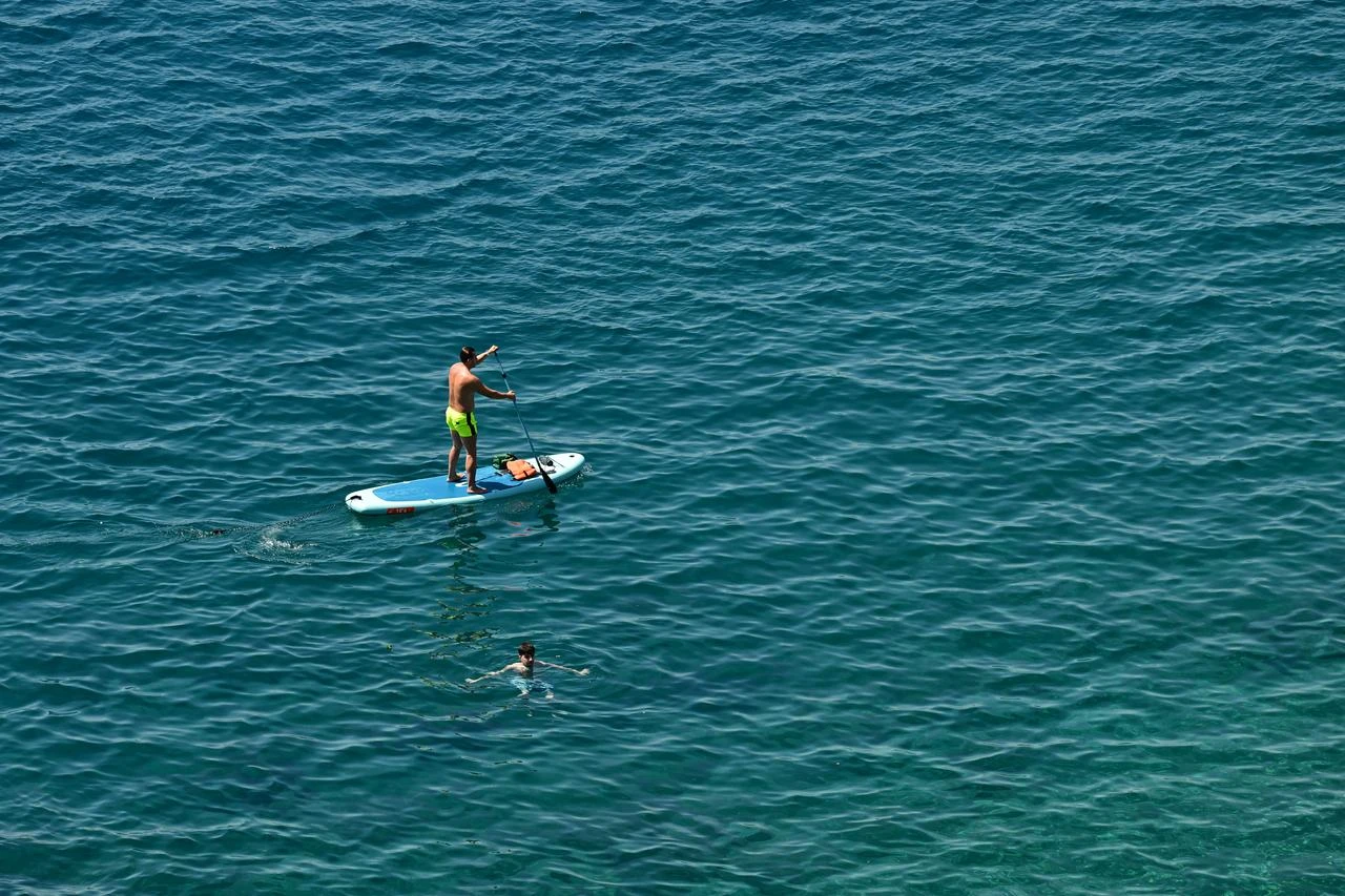 People swim and paddleboard in the Mediterranean Sea off the coast of Antalya, Türkiye. (AA Photo)
Beachgoers
