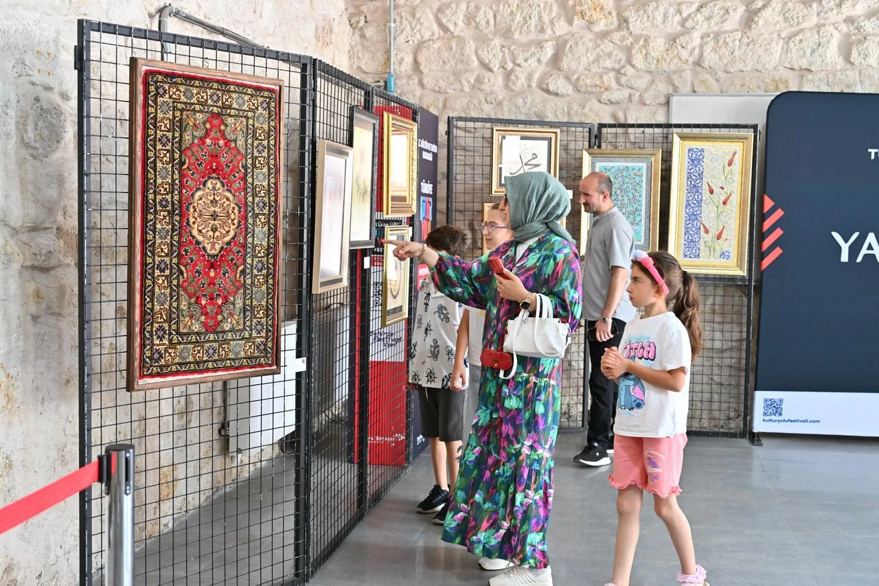 Visitors view traditional artworks and carpets at an exhibition held during the Türkiye Culture Route Festival in Cappadocia, Nevsehir, Türkiye. (AA Photo)