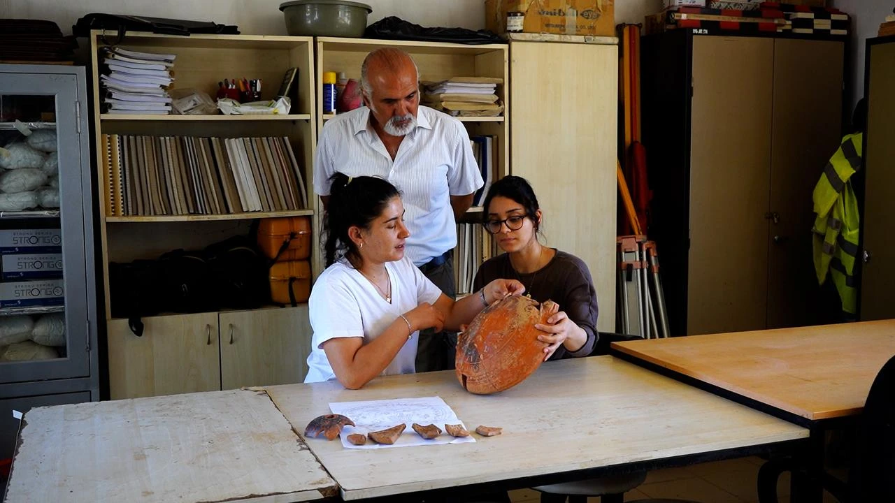 Archaeologists examine the sixth-century liturgical vessel uncovered during excavations at Antioch of Pisidia in Isparta, Türkiye. (AA Photo)