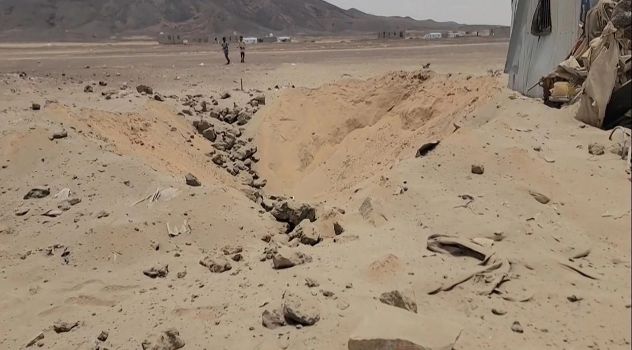 This frame grab taken from AFPTV footage shows people walking near damaged shelters at the Mail al-Saila internally displaced persons (IDP) camp on the outskirts of Marib, Yemen, Aug. 7, 2026. (AFP Photo)