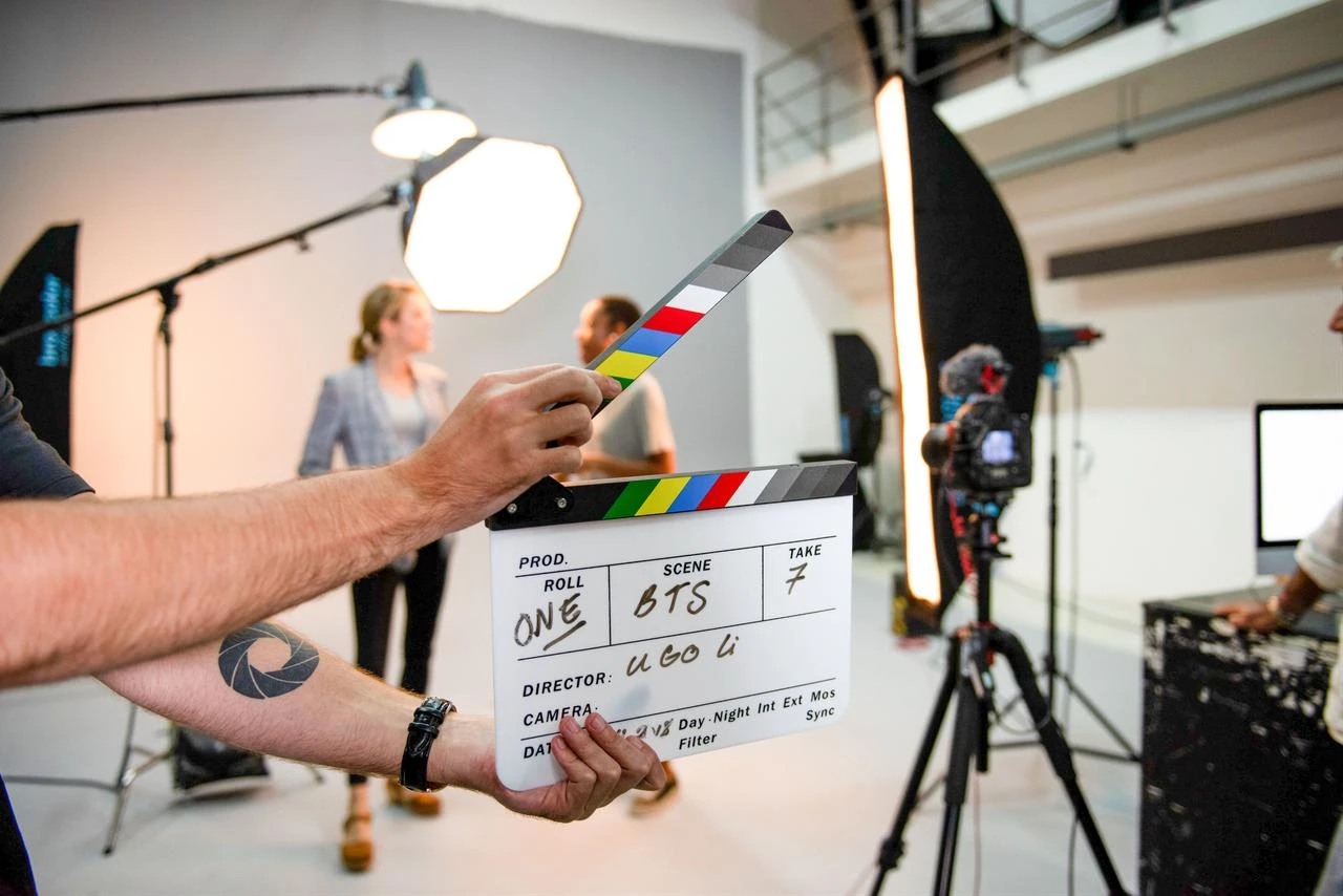 A film crew uses a clapperboard during a video production shoot in a studio. (Adobe Stock Photo)
