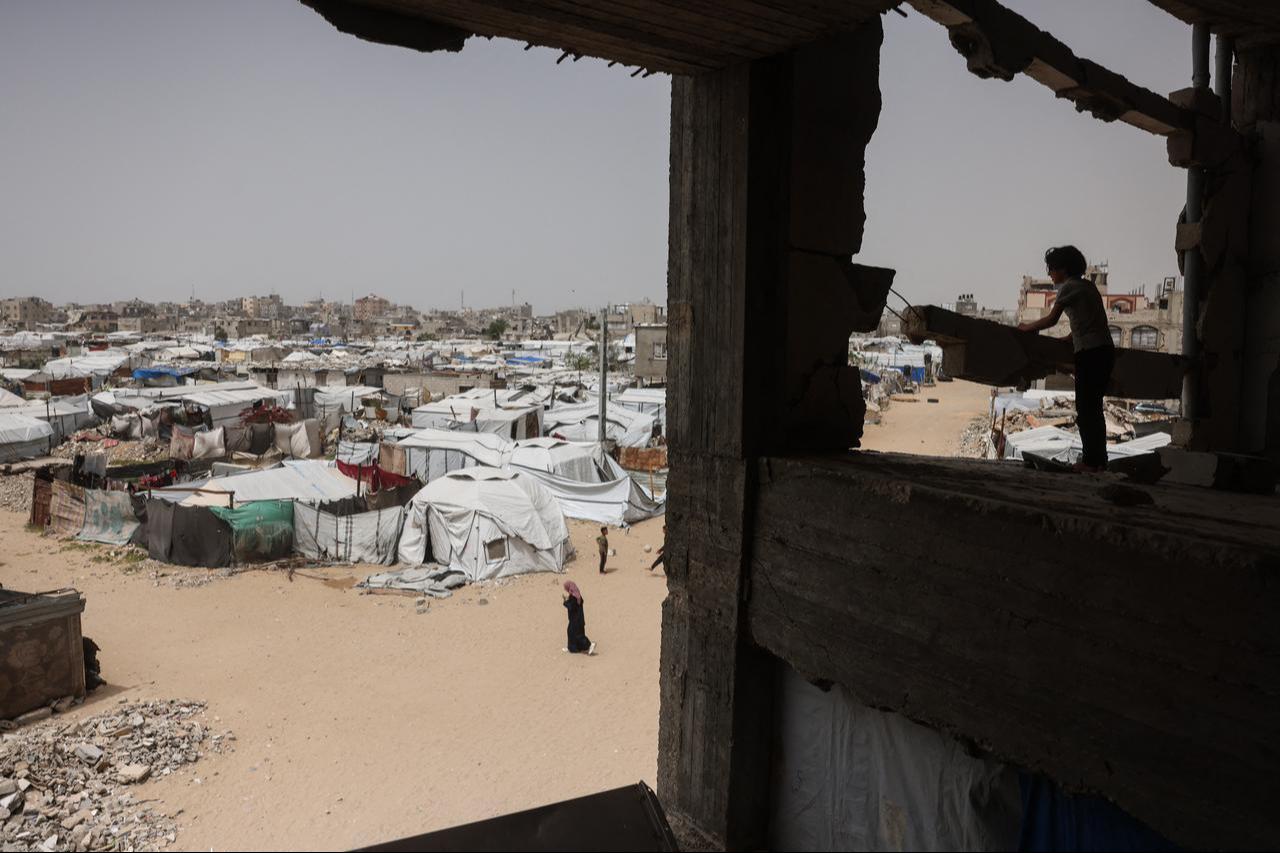 A child stands in a destroyed building overlooking makeshift shelters for displaced Palestinians in Khan Yunis in the southern Gaza Strip on April 18, 2026. (AFP Photo)