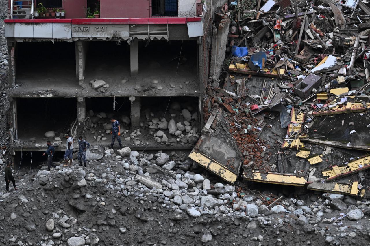 Security personnel inspect buildings and debris destroyed by catastrophic flash floods in Nuwakot district, Nepal, Sept. 1, 2026. (AFP Photo)