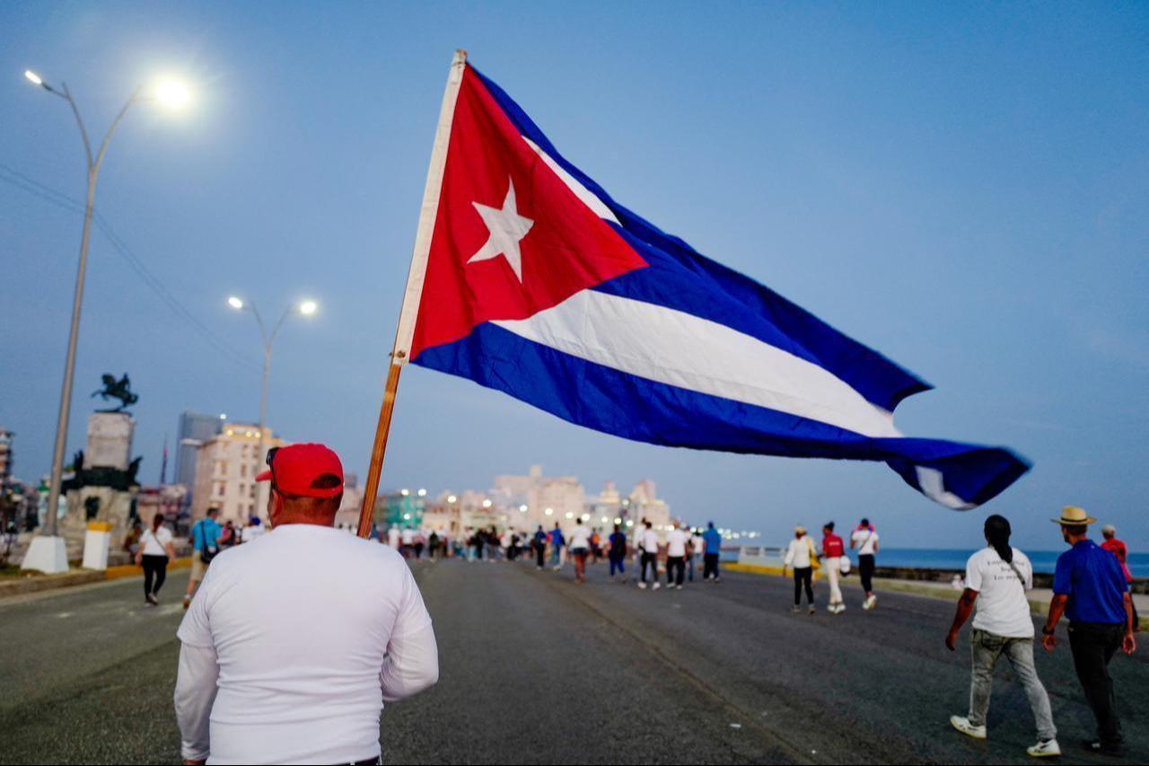A man marches holding a Cuban national flag along Havana’s waterfront to mark International Workers’ Day in front of the US Embassy in Havana, May 1, 2026. (AFP Photo)