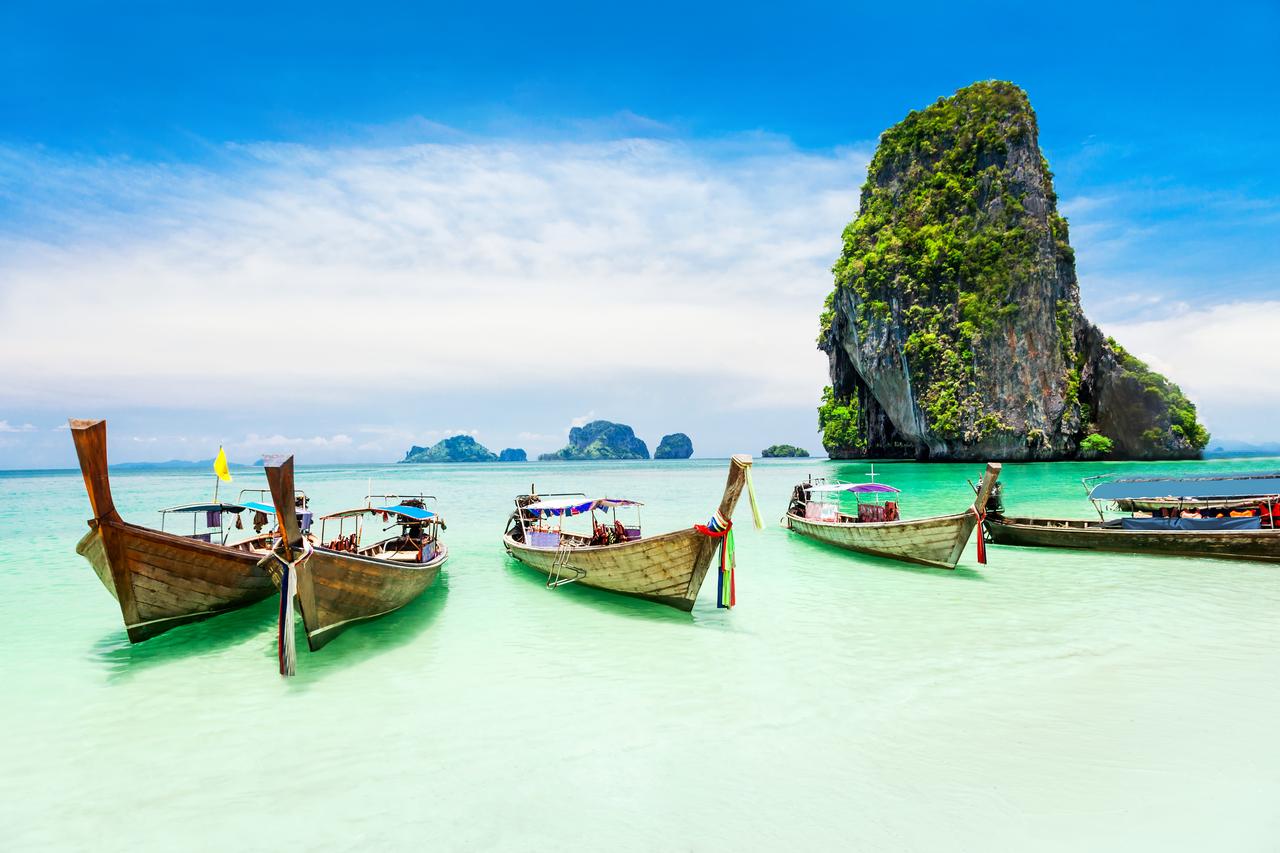 Vendors sell fresh produce and food from wooden boats at a floating market in Thailand. (Adobe Stock Photo)