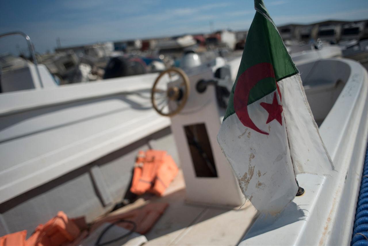An Algerian flag is displayed on a small boat used by migrants to cross The Alboran Sea, in an open-air warehouse in Almeria, southeast Spain, on October 15, 2021. (AFP Photo)