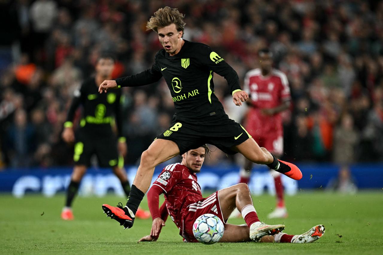 Atletico Madrid's Spanish midfielder #08 Pablo Barrios jumps over Liverpool's Hungarian defender #06 Milos Kerkez during the UEFA Champions League football match between Liverpool and Atletico Madrid at Anfield in Liverpool, north west England on September 9, 2026. (AFP Photo)
