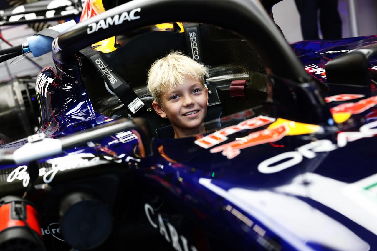 Robin Raikkonen poses for a photo sitting inside a Red Bull Formula 1 car. (Photo via Formula 1)