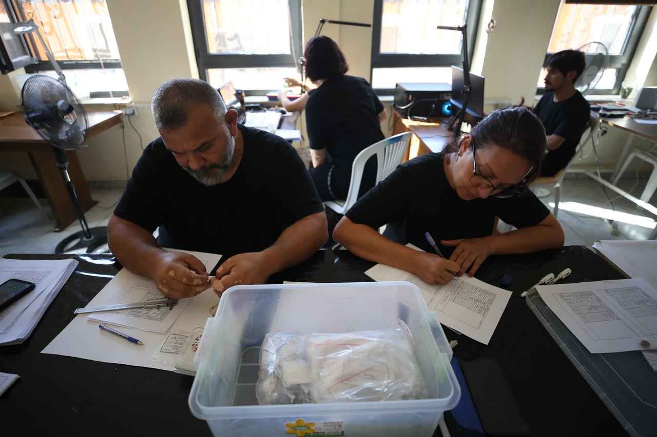 Members of the Andik Cave excavation team examine and document archaeological material recovered during fieldwork in Havran, Balikesir, Türkiye. (AA Photo)
