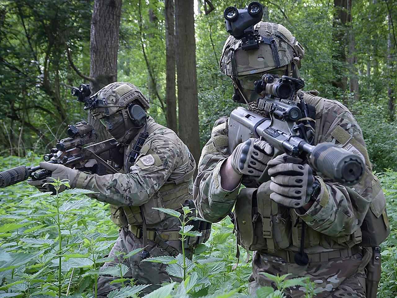 The photo shows an Alfa-Metal operator, camouflaged, stalking through a forest with a silenced assault rifle at an unspecified location and time. (Photo via alfa-metal.com)