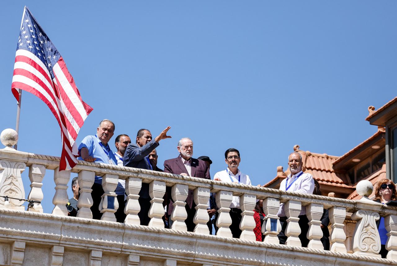 US Ambassador to Israel Mike Huckabee (C) stands on the roof of a home belonging to an Palestinian-American resident as he surveys the Jewish settlement erected close to the Israeli-occupied West Bank town of Turmus Ayya, on September 5, 2026. (AFP Photo)