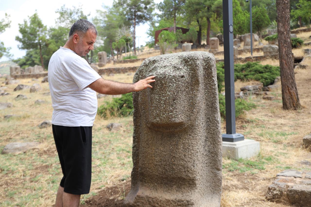 A visitor examines an ancient stone sculpture at the Yesemek Open-Air Museum and Sculpture Workshop in Gaziantep, Türkiye. (IHA Photo)