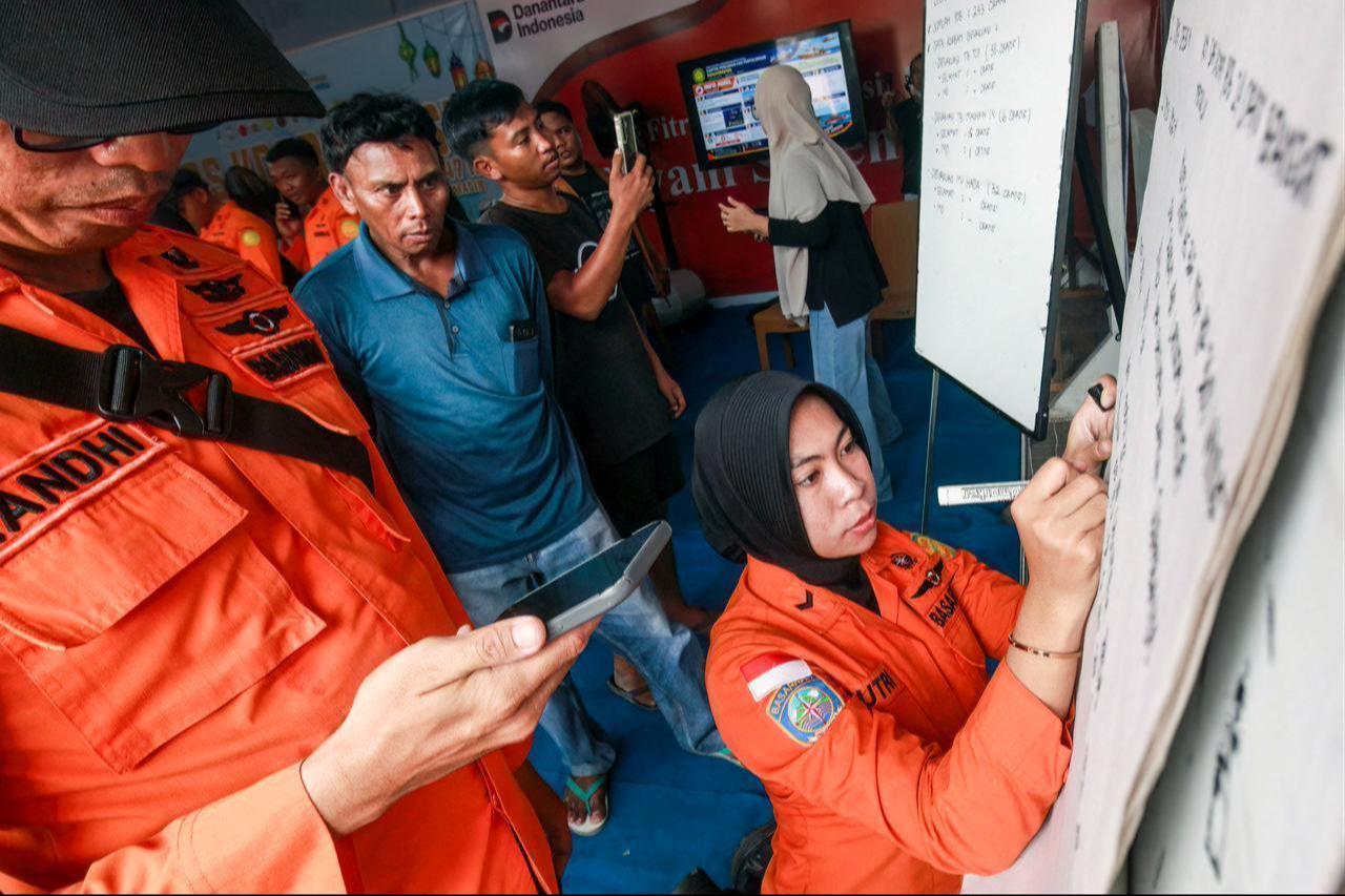 Relatives of affected passengers look on as a Basarnas officer writes updates on a whiteboard amid ongoing rescue operations on the stricken Virgo Transport 8 ferry in Banjarmasin, South Kalimantan, Sept. 13, 2026. (AFP Photo)