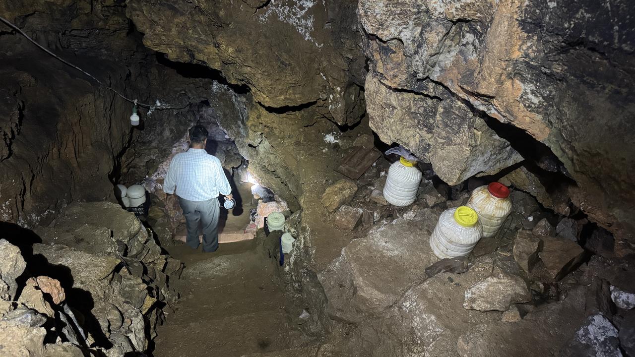 A man walks through the cave, where containers of dairy products are stored on the rocky ledges, in Gokceyurt Neighborhood in Konya's Ilgin district, Türkiye. (AA Photo)
