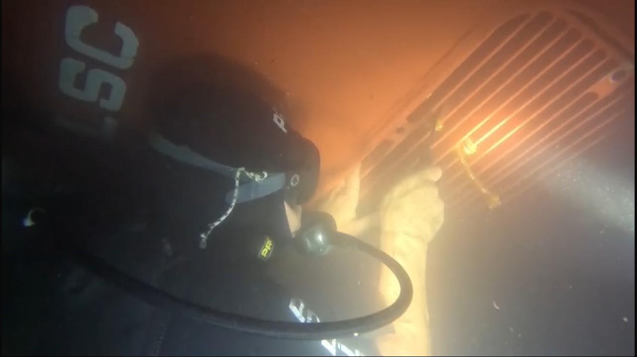 The photo shows a Turkish police diver opening a hidden compartment beneath a cargo ship to retrieve drugs that had arrived at Mersin Port from Brazil on Sept. 13, 2026. (IHA Photo)