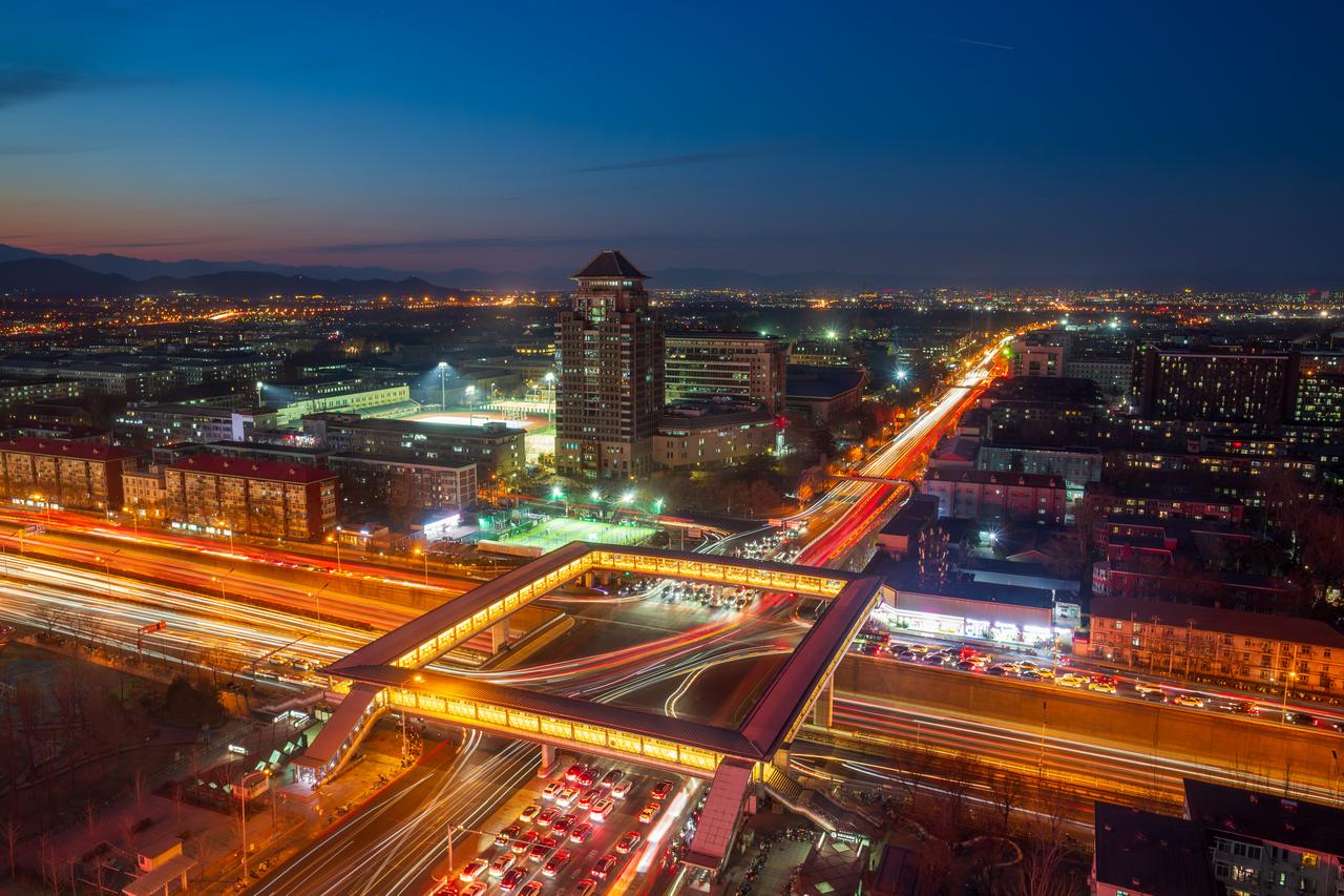 Aerial view of Zhongguancun city nightscape and traffic hub vehicle flow, Beijing, China. (Photo via Adobe Stock)