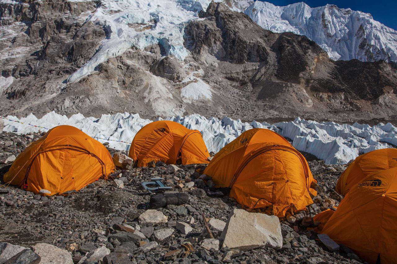 Expedition tents stand amid rock and ice in the Himalayas, where a new report says glacier mass loss has accelerated sharply over the past decade. (Adobe Stock Photo)