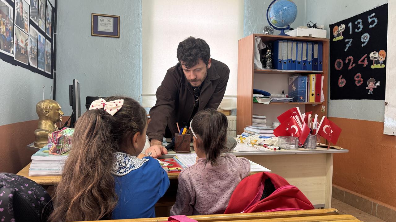 Muhammed Bag guiding his two students at their desk inside Sehit Mustafa Kozlu Primary School in the Gokceyurt neighborhood of Konya's Ilgin district. (AA Photo)