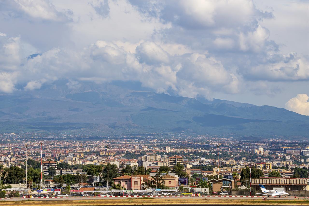 Mount Etna is seen beneath a thick ash cloud behind Catania and Catania-Fontanarossa Airport in Sicily, Italy, Sept. 15, 2026. (AA Photo)