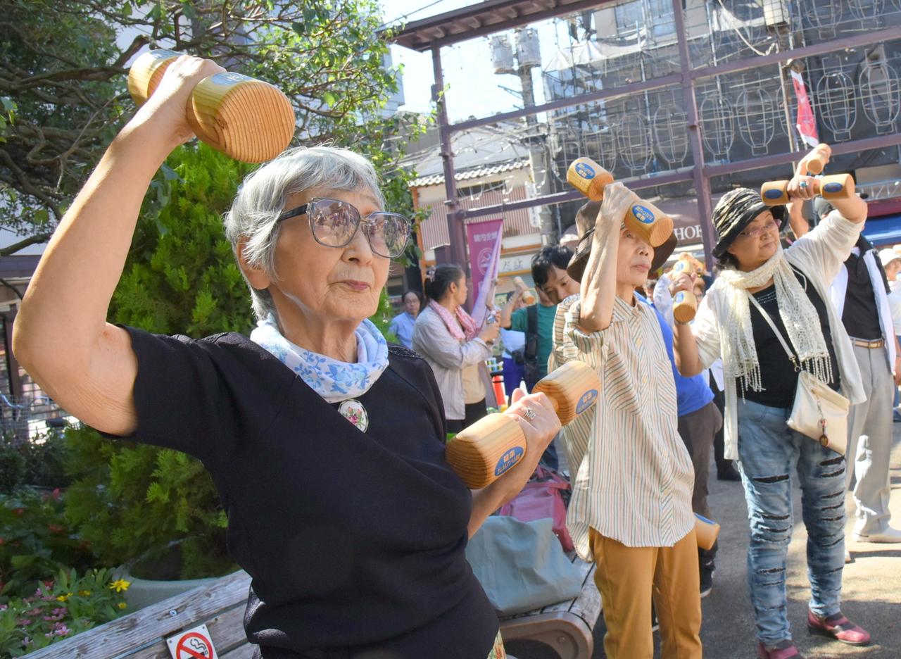 Elderly and middle-aged people exercise with wooden dumbbells during a health promotion event to mark Respect for the Aged Day at a temple in Tokyo's Sugamo district, an area popular among the elderly, on September 18, 2017. (Photo by Satoko Kawasaki)