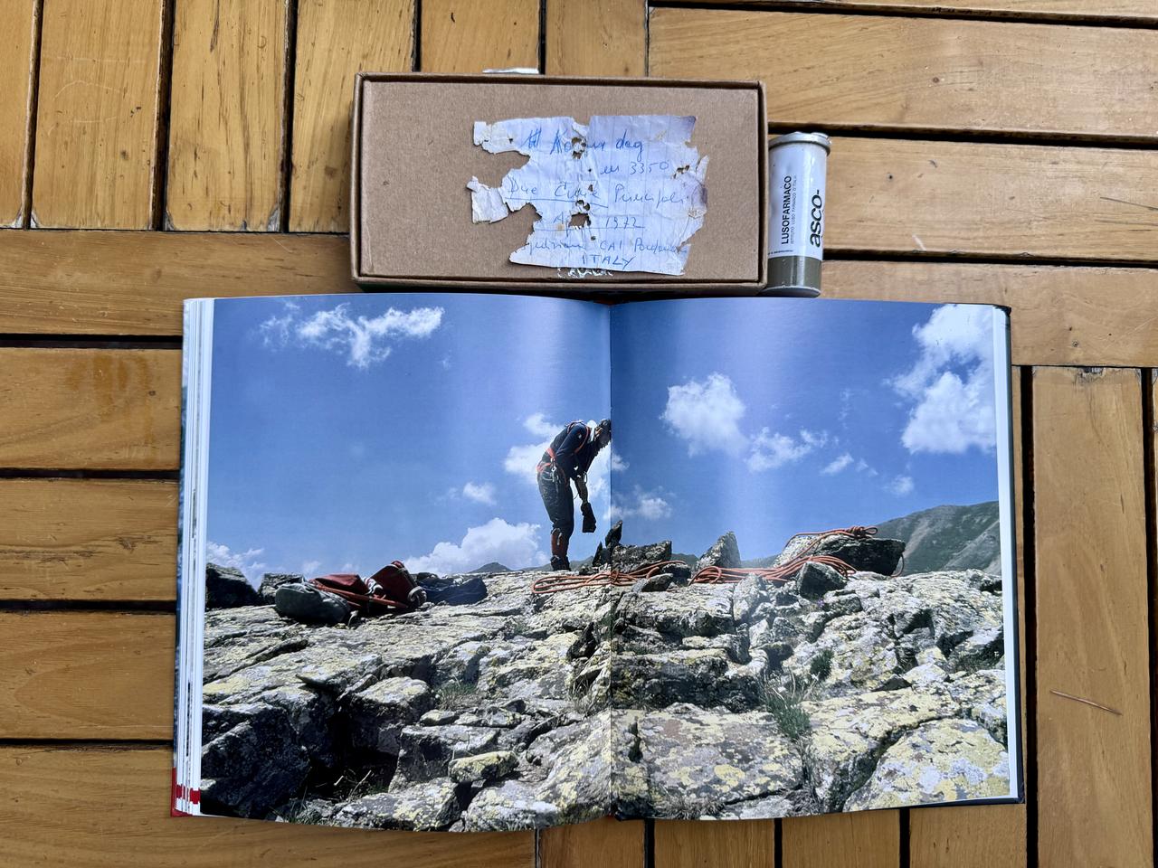 An effervescent tablet container containing a 1972 expedition note that Turkish mountaineers found is displayed alongside a book documenting the Italian expedition to the Kackar Mountains in Trabzon, Türkiye, Sept. 15, 2026. (AA Photo