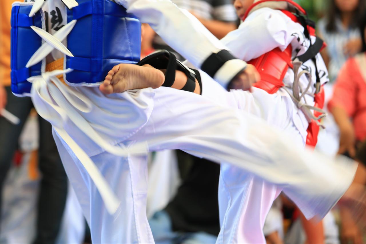 Taekwondo athletes spar during a martial arts competition. (Adobe Stock Photo)