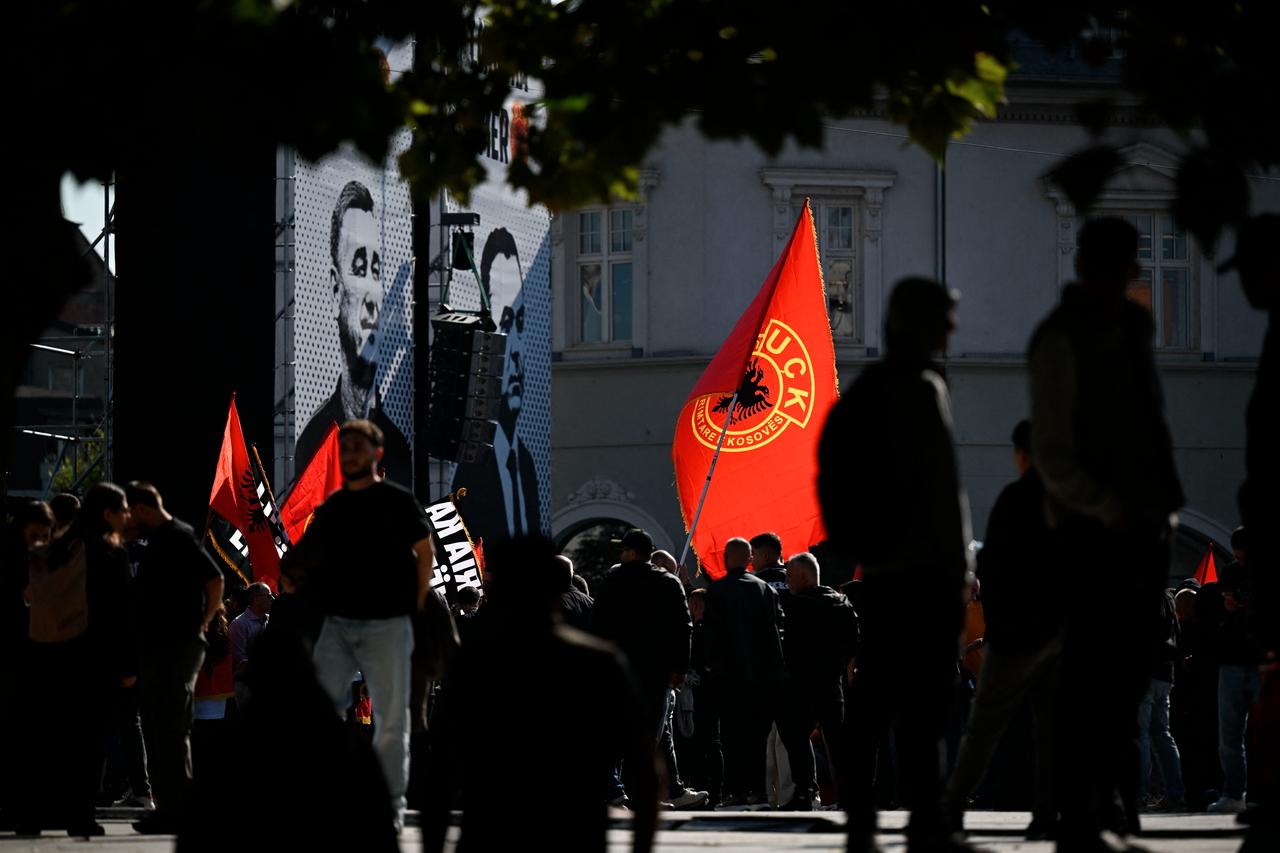 Kosovo Albanians hold flags in front of posters featuring Kosovo Liberation Army (KLA) leaders in Pristina as they wait outside the Kosovo Specialist Chambers (KSC) for a verdict in the trial against former Kosovar President Hashim Thaci and three former KLA leaders in The Hague on September 16, 2026. (AFP Photo)
