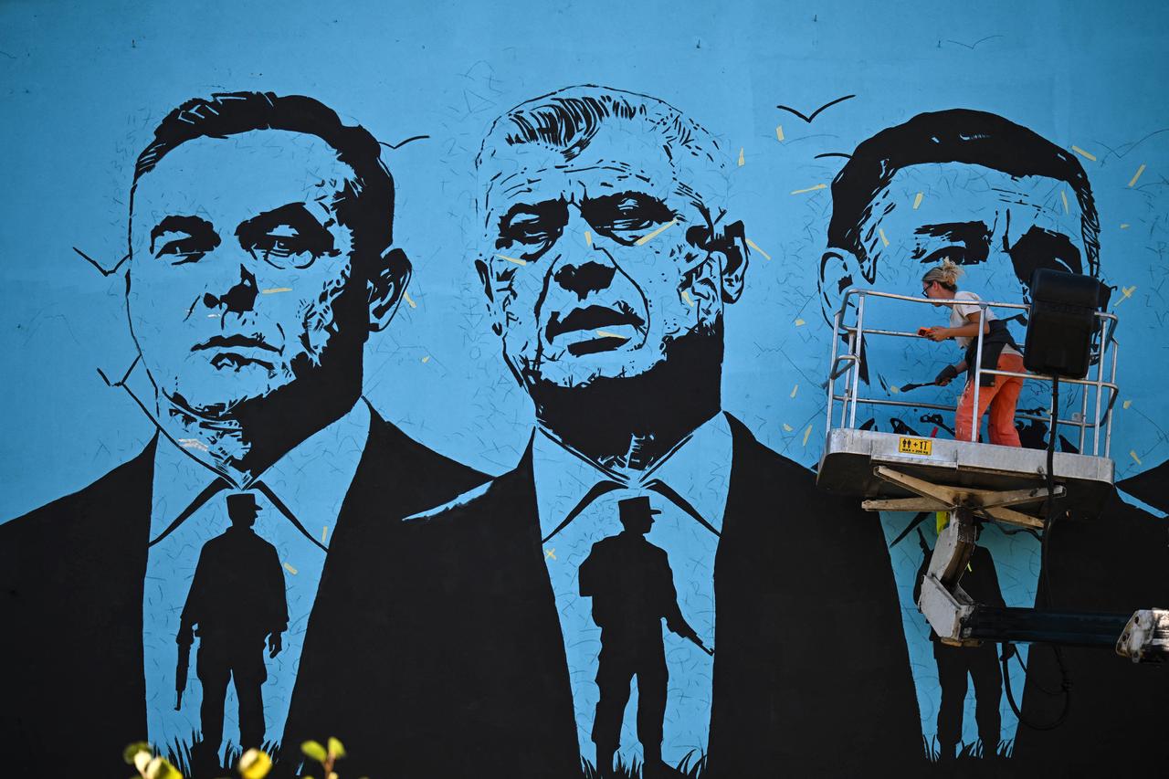 This photograph shows Kosovo's Artist Ermira Murati working on his mural depicting former Kosovo's Presidents Hashim Thaci, Jakup Krasniqi and Kadri Veseli in Pristina on September 8, 2026. allegedly committed by KLA members during the 1998-1999 independence war with Serbia. (Photo by Armend NIMANI / AFP)
