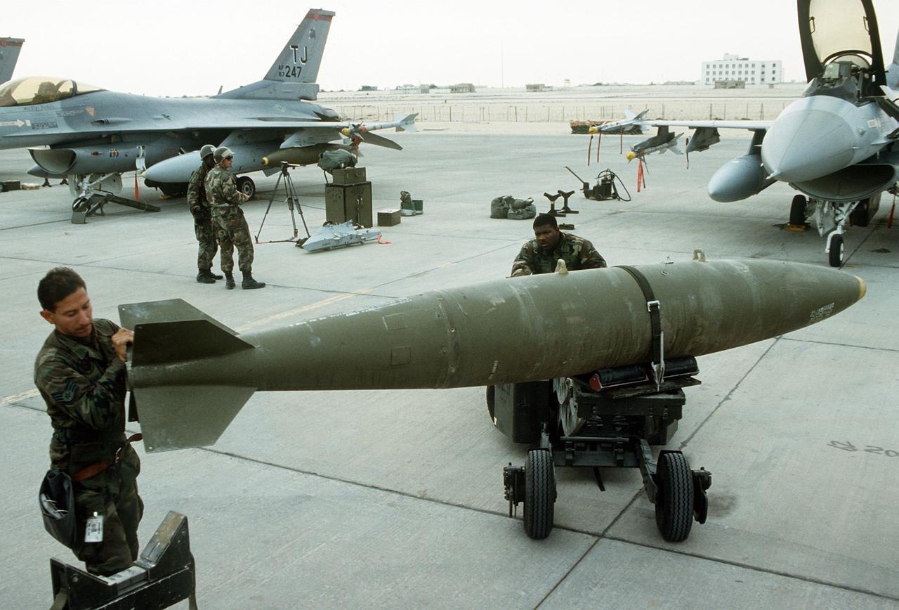 U.S. Air Force ground crew members prepare to load a Mark 84 2,000-pound bomb onto an F-16 Fighting Falcon during Operation Desert Storm in February 1991. (Photo via Wikimedia Commons)