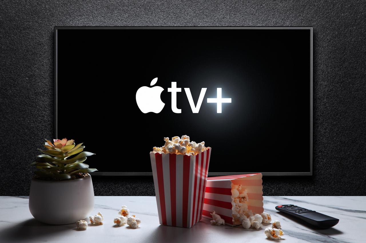 The Apple TV+ logo appears on a television screen alongside popcorn and a remote control. (Adobe Stock Photo)