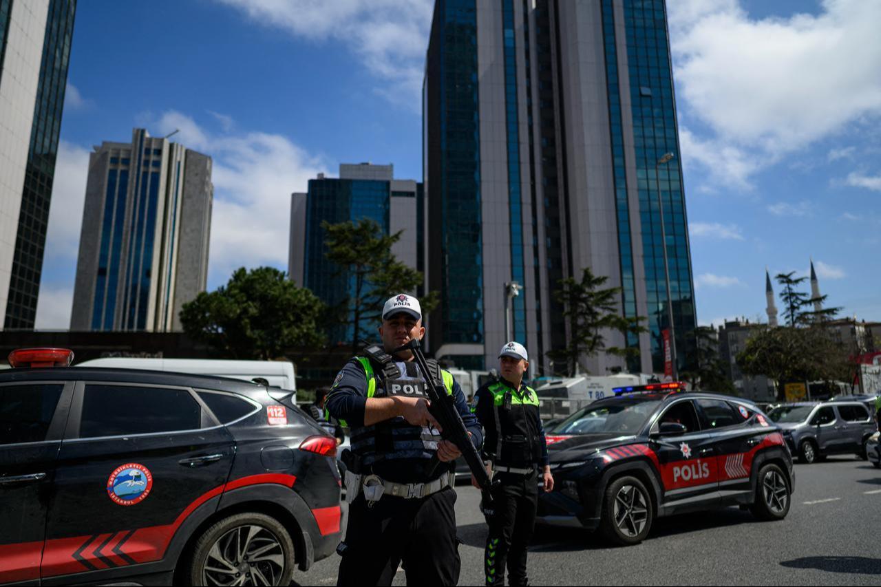 Police officials stand amongst traffic as they patrol near the Israeli Consulate in Istanbul on April 7, 2026, following a shootout between gunmen and police. (AFP Photo)