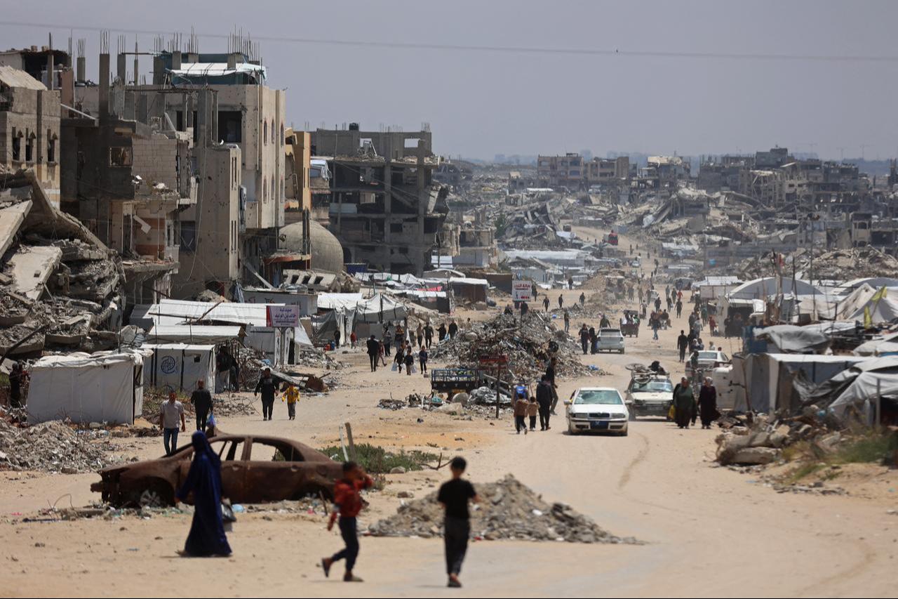Displaced Palestinians make their way along a street with destroyed buildings at Jabalia in the northern Gaza Strip, May 6, 2026. (AFP Photo)