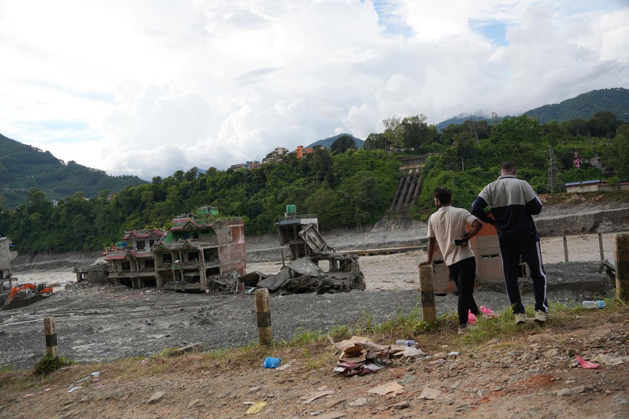 Residents stand among belongings and debris outside a flood-damaged building in Nuwakot, Nepal, Sept. 1, 2026. (AA Photo)