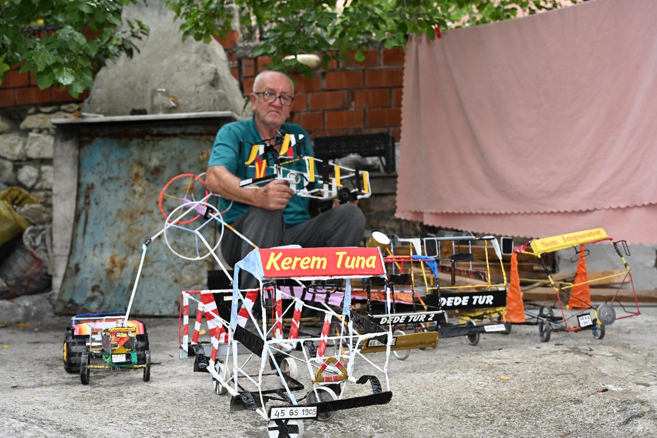 Ali Riza Isci poses with his handmade toy wire cars, which he builds to encourage children to reduce screen time. (AA Photo)